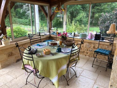 a table in a conservatory with a table and chairs at Domaine du Roucou in Nabirat