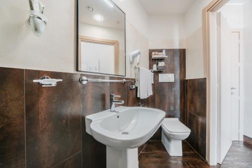 a bathroom with a sink and a toilet and a mirror at Hotel Milano Navigli in Milan