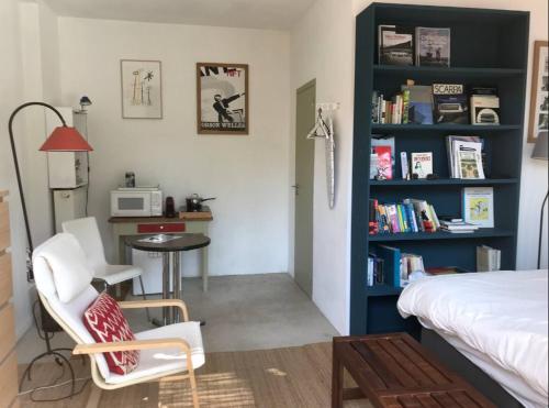 a bedroom with a bed and a desk and a table at Studio calme idéal pour déplacement professionnel, dans une maison in Sceaux