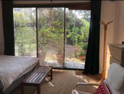 a bedroom with a bed and a large window at Studio calme idéal pour déplacement professionnel, dans une maison in Sceaux