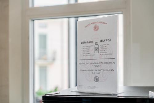 a sign sitting on a table in front of a window at Hotel Milano Navigli in Milan