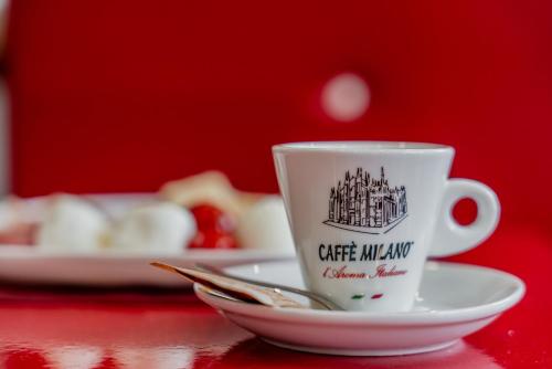 a coffee mug sitting on a plate on a table at Hotel Milano Navigli in Milan