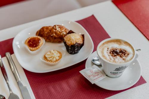 a plate of muffins and a cup of coffee on a table at Hotel Milano Navigli in Milan