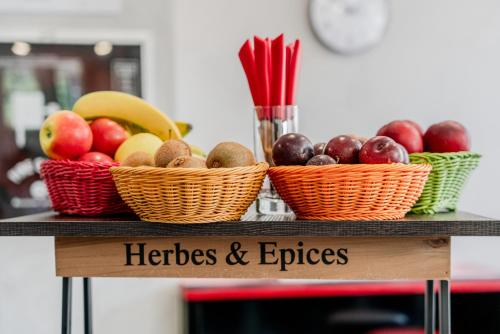 three baskets of fruits and vegetables on a table at Hotel Milano Navigli in Milan