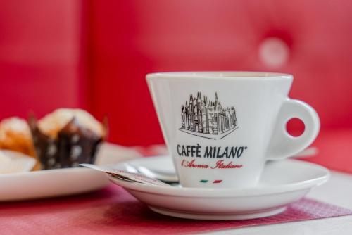 a cup of coffee on a table with a plate of food at Hotel Milano Navigli in Milan