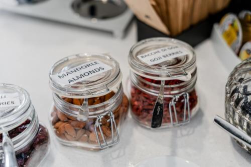 three jars of nuts and dried fruits on a counter at Hotel Milano Navigli in Milan
