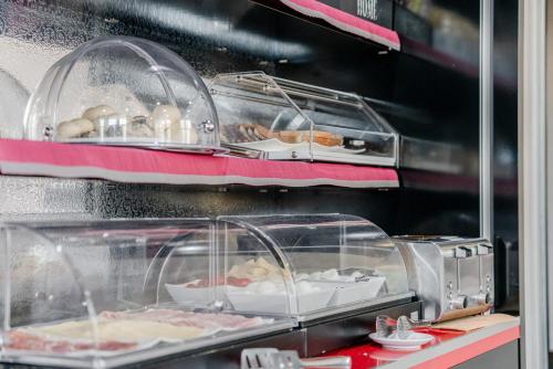 a display case with some food on a shelf at Hotel Milano Navigli in Milan