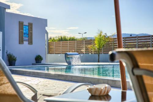 a view of a swimming pool with a table and chairs at Tommy's Rooms in Haraki