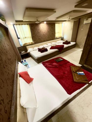 a large room with three beds with red sheets at Hotel City Gold in Ajmer