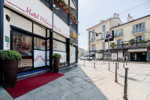a street with buildings and a red rug in front of a store at Hotel Milano Navigli in Milan