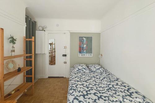 une chambre avec un lit avec une couette bleue et blanche dans l'établissement Flexliving - Studio - Championnet, à Paris