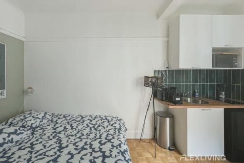 - une cuisine avec un lit et un évier dans la chambre dans l'établissement Flexliving - Studio - Championnet, à Paris