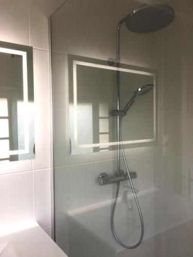une douche avec pommeau de douche dans une salle de bain dans l'établissement St-Clair Villa, piscine & pinède, à Sète