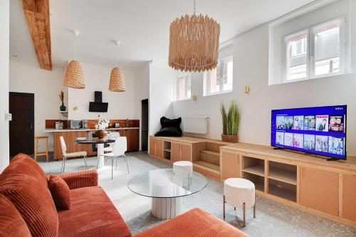 un salon avec un canapé et une télévision dans l'établissement Authentique Apartment - 1BR-4P - Saint-Ouen, à Saint-Ouen
