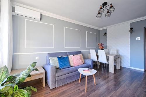 カトヴィツェにあるComfyApartment/L9Aの青いソファとテーブルのあるリビングルーム