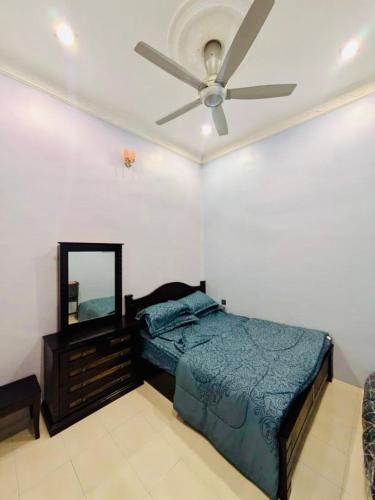 a bedroom with a bed and a ceiling fan at Seri Changkat Homestay in Kampong Changkat Raja