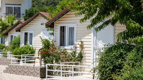 a white house with plants in front of it at Imeros Hotel Beldibi in Beldibi
