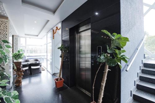 a hallway with potted plants and stairs in a house at FabHotel Prime Suloka Towers - 500m from View point, Kaveri River in Kushālnagar