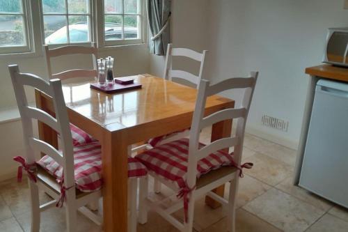 a dining room table with four chairs and a table and chairsktop at Well Cottage in Beckington
