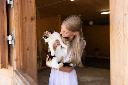 a woman holding a cat in her arms at Almfamilyhotel Scherer in Obertilliach