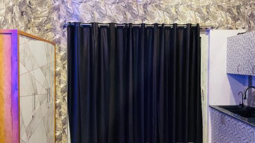 a black curtain on the side of a wall at Auro studio home in Pūrnānkuppam