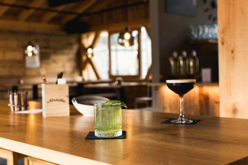 a glass of wine sitting on top of a bar at Almfamilyhotel Scherer in Obertilliach
