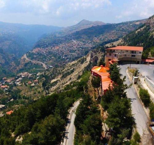 a building on the side of a mountain with a road at Hotel L'Aiglon in Bcharré