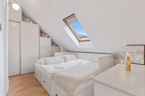 Un dormitorio blanco con una cama y un tragaluz. en Charming design old town apartment, en Staré Mesto