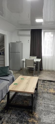 a living room with a table and a refrigerator at Guesthouse Next to beach in Batumi