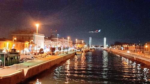 a plane is flying over a river at night at The Stopover Suite House 2 in Fiumicino