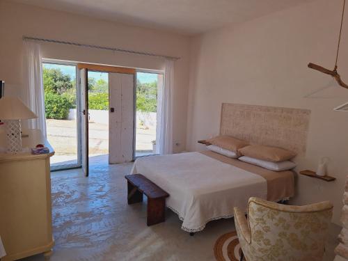 een slaapkamer met een bed en een glazen schuifdeur bij Holiday Home Trullo Antico in Ostuni