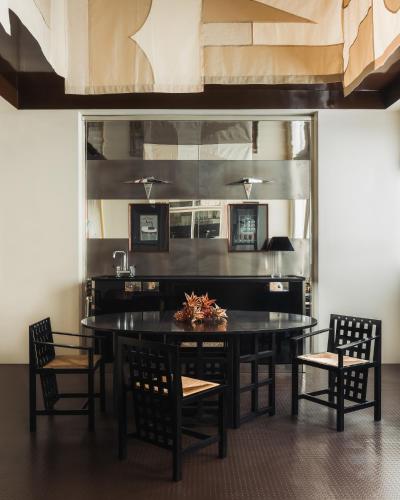 une salle à manger avec une table et des chaises noires dans l'établissement Pied A Terre Oberkampf, à Paris