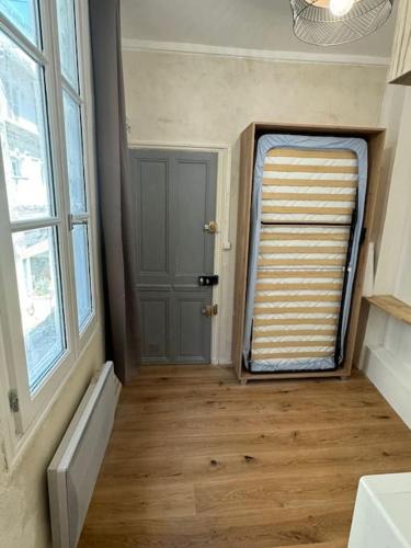 une pièce avec une porte, une fenêtre et un plancher en bois dans l'établissement Studio - Chambre Avignon centre, à Avignon