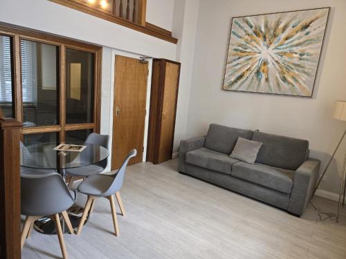 a living room with a couch and a table and chairs at Aspen Hotel in London