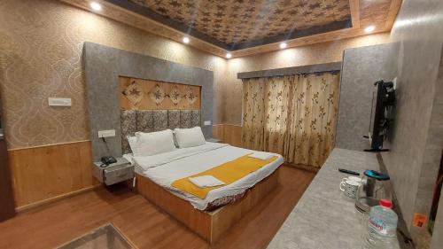 a bedroom with a bed and a tv in it at Hotel Outlook - Pahalgam in Pahalgām