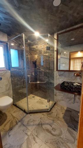 a bathroom with a shower with a glass shower stall at Hotel Outlook - Pahalgam in Pahalgām