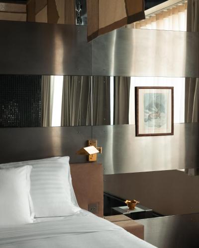 une chambre avec un lit et une table avec une lampe dans l'établissement Pied A Terre Oberkampf, à Paris