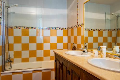 a bathroom with two sinks and a mirror and a tub at Amaltea in Candeleda