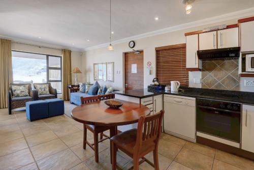 a kitchen and living room with a table and chairs at Makarios On Sea in Herolds Bay
