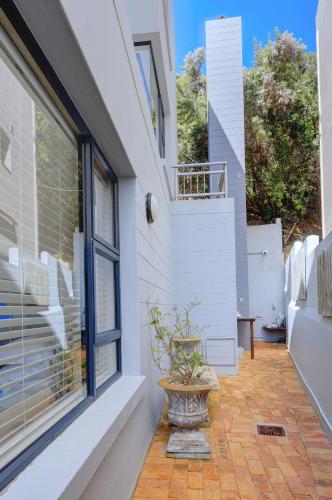 a patio with a window and a potted plant at Makarios On Sea in Herolds Bay