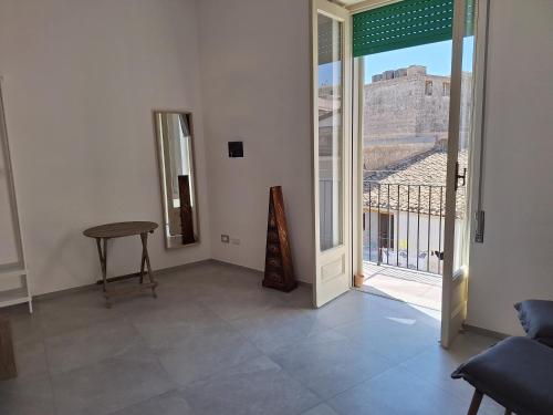 a room with a table and a balcony with a view at Pura Vida Barocca in Ragusa