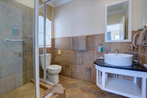 a bathroom with a toilet and a sink and a shower at Makarios On Sea in Herolds Bay