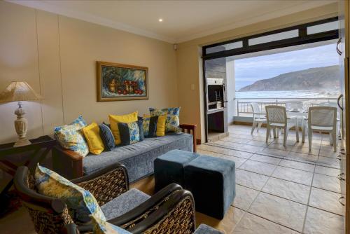 a living room with a couch and a table at Makarios On Sea in Herolds Bay