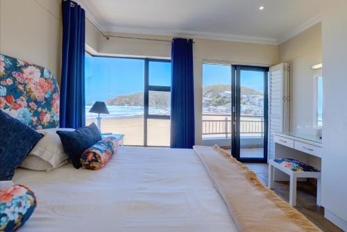 a bedroom with a bed with a view of the beach at Makarios On Sea in Herolds Bay