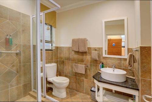 a bathroom with a toilet and a sink and a shower at Makarios On Sea in Herolds Bay