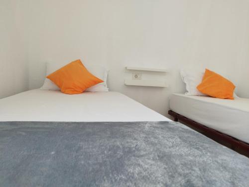 ein Schlafzimmer mit einem Bett mit orangefarbenen Kissen darauf in der Unterkunft Casa Padrón! Paraíso junto al MAR in Puerto de Santiago