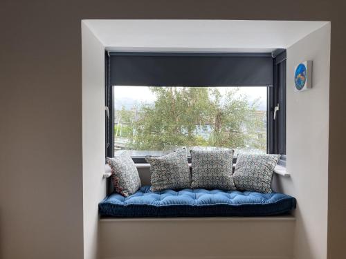 a window seat with a blue couch in front of a window at In The Pink in Dungarvan