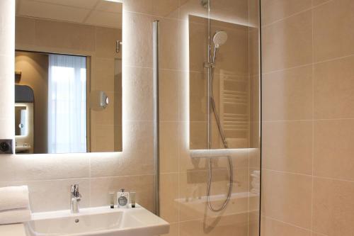 a bathroom with a shower and a sink at Brit Hotel Limoges Centre Gare - Hôtel & Spa in Limoges