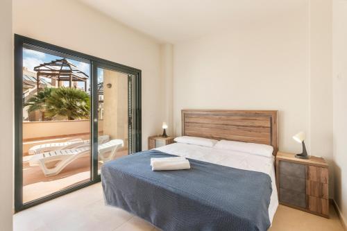 a bedroom with a large bed and a balcony at El Oasis Martinica 2 Bajo B in Fuente Alamo
