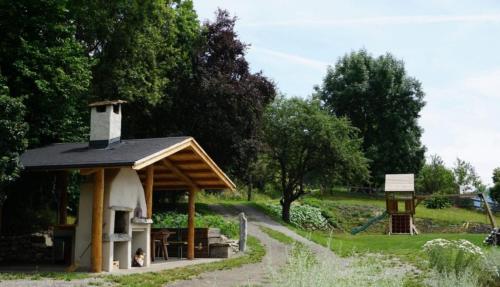 a small building in a field with a playground at Vitalhof am Kreischberg by ALPS RESORTS in Bodendorf